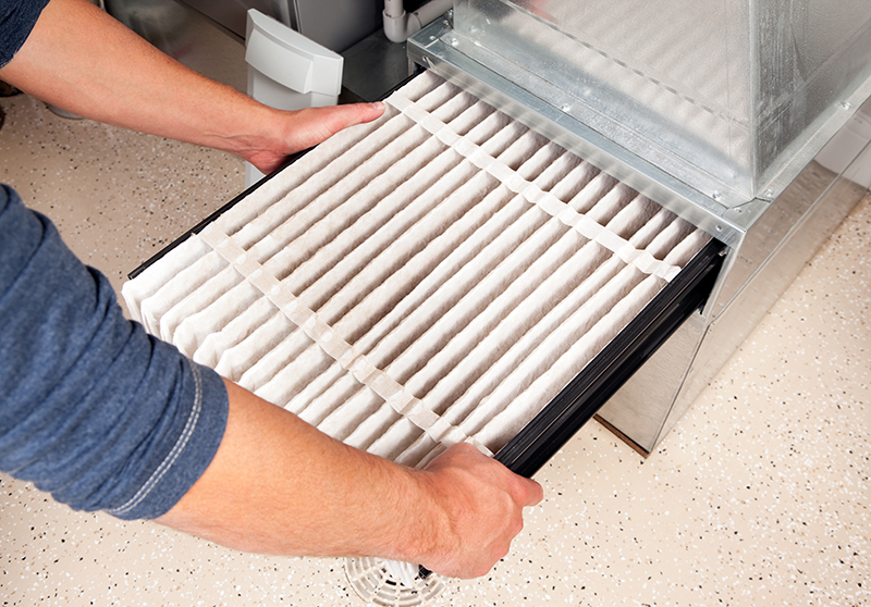 arms of a technician replacing a hvac filter